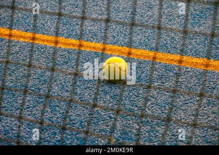 Balle de tennis près de la ligne sur un court de tennis fermé Banque D'Images