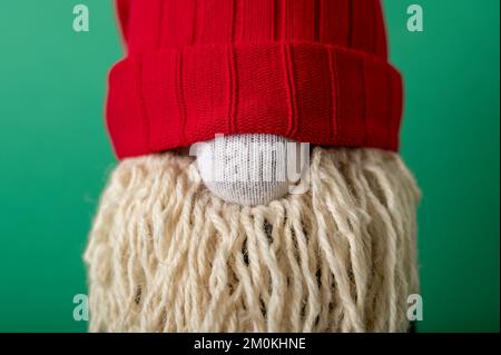 Gnome de Noël fait main sur fond vert. Upcycle, fait de vieilles chaussettes. Gros plan portrait Banque D'Images