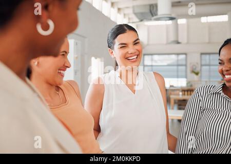 Groupe diversifié de femmes d'affaires heureuses ayant une réunion au travail. Des hommes d'affaires joyeux qui parlent et rient en se tenant dans un bureau Banque D'Images