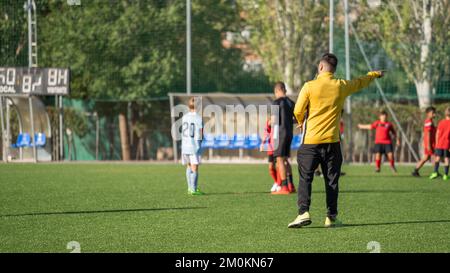 Entraîneur de football donnant des instructions à l'équipe de football des enfants pendant le match. Banque D'Images