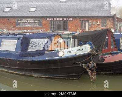 Un matin d'hiver froid et brumeux sur le canal de Grand Union, Blisworth, Northamptonshire, Royaume-Uni; avec des bateaux étroits amarrés à l'extérieur d'une cour de bateaux Banque D'Images