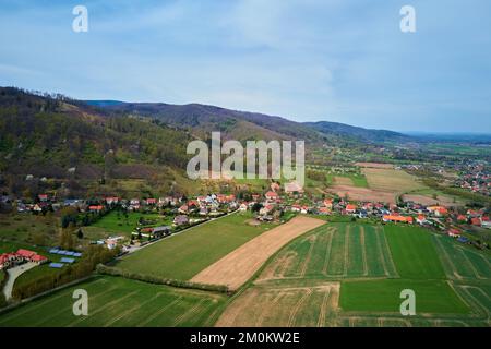 Vol de drone au-dessus du village de montagne parmi les champs agricoles verts, vue sur la campagne, paysage de la nature Banque D'Images