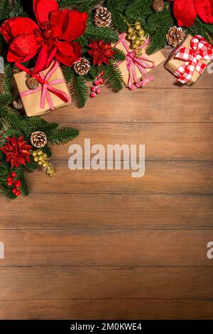 Noël traditionnel, vacances du nouvel an arrière-plan avec branches d'arbre de Noël, baies rouges d'hiver, fleurs de poinsettia, boîtes-cadeaux, sur le dos en bois Banque D'Images