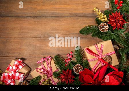 Noël traditionnel, vacances du nouvel an arrière-plan avec branches d'arbre de Noël, baies rouges d'hiver, fleurs de poinsettia, boîtes-cadeaux, sur le dos en bois Banque D'Images