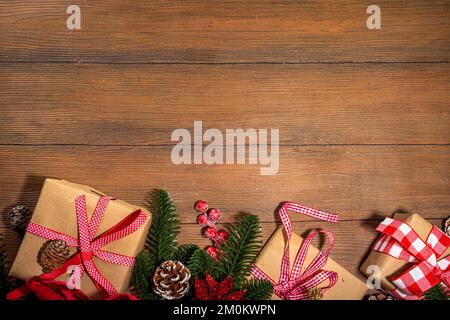 Noël traditionnel, vacances du nouvel an arrière-plan avec branches d'arbre de Noël, baies rouges d'hiver, fleurs de poinsettia, boîtes-cadeaux, sur le dos en bois Banque D'Images