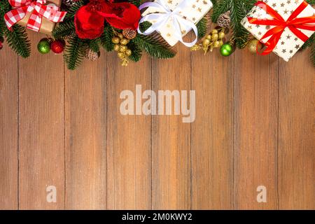 Noël traditionnel, vacances du nouvel an arrière-plan avec branches d'arbre de Noël, baies rouges d'hiver, fleurs de poinsettia, boîtes-cadeaux, sur le dos en bois Banque D'Images