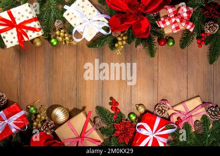 Noël traditionnel, vacances du nouvel an arrière-plan avec branches d'arbre de Noël, baies rouges d'hiver, fleurs de poinsettia, boîtes-cadeaux, sur le dos en bois Banque D'Images