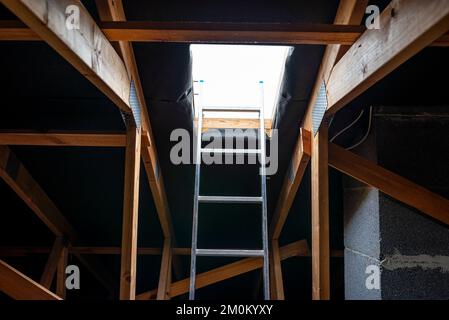Une trappe de toit ouverte dans le grenier pour un balayage de cheminée, une échelle debout dans la fenêtre. Banque D'Images