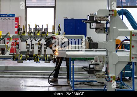 HEFEI, CHIAN - DECEMBER7, 2022 - Un ouvrier travaille devant un poste de soudage de réparation à l'atelier n° 1 de logement de batterie au Guoxuan High-Tech Banque D'Images