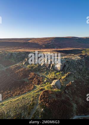 Ilkley, Royaume-Uni. 7th décembre 2022. Météo au Royaume-Uni : ce matin, des conditions glaciales glaciales à travers le West Yorkshire et un ciel bleu et ensoleillé au-dessus d'Ilkley. Vue aérienne des formations rocheuses de Cow et Calf au-dessus d'Ilkley sur Ilkley Moor. Crédit : Bradley Taylor / Alamy News. Banque D'Images