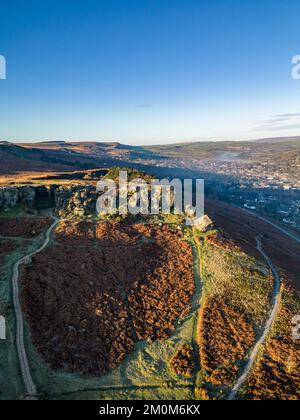 Ilkley, Royaume-Uni. 7th décembre 2022. Météo au Royaume-Uni : ce matin, des conditions glaciales glaciales à travers le West Yorkshire et un ciel bleu et ensoleillé au-dessus d'Ilkley. Vue aérienne des formations rocheuses de Cow et Calf au-dessus d'Ilkley sur Ilkley Moor. Crédit : Bradley Taylor / Alamy News. Banque D'Images