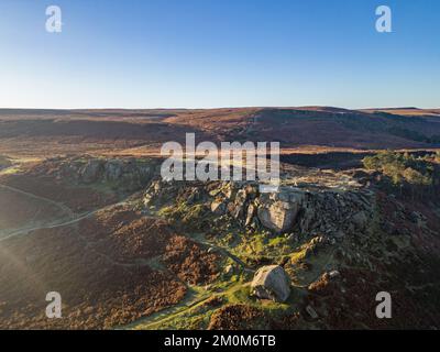 Ilkley, Royaume-Uni. 7th décembre 2022. Météo au Royaume-Uni : ce matin, des conditions glaciales glaciales à travers le West Yorkshire et un ciel bleu et ensoleillé au-dessus d'Ilkley. Vue aérienne des formations rocheuses de Cow et Calf au-dessus d'Ilkley sur Ilkley Moor. Crédit : Bradley Taylor / Alamy News. Banque D'Images