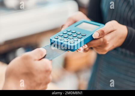 Gros plan d'un employé acceptant un paiement par carte de crédit d'un client dans un café ou un magasin. Mains de la femme utilisant le lecteur de machine à cartes pour traiter sans espèces Banque D'Images