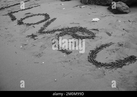 Photo noir et blanc, photo monochrome d'un mot « i love u » sur la plage de sable Banque D'Images