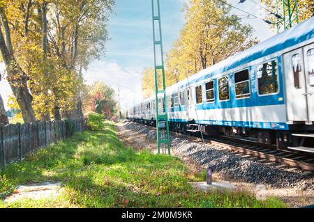 Le train de voyageurs traverse un passage à niveau en milieu rural. Après que la barrière de circulation a été abaissée photographiée au lac Balaton, en Hongrie Banque D'Images