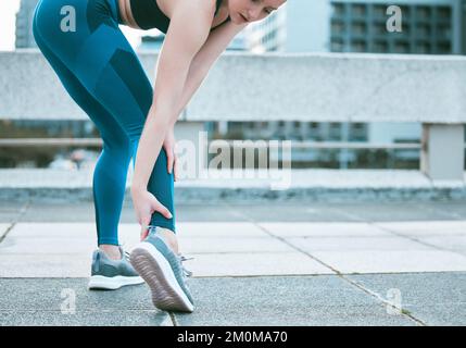 Gros plan d'une femme caucasienne tenant sa cheville douloureuse tout en faisant de l'exercice à l'extérieur. Une athlète féminine souffrant de blessures douloureuses au pied causées par une fracture Banque D'Images