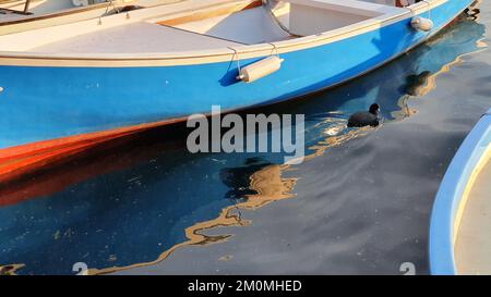 un petit bateau se reflète à la surface de la mer Banque D'Images