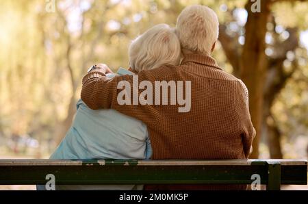 Détendez-vous, carchez et aimez avec un vieux couple dans le parc pour le bonheur, le mariage et le calme. La paix, la nature et la retraite avec l'homme embrassant la femme à la table pour Banque D'Images