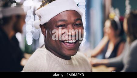 Portrait, fête et homme heureux lors de l'événement de noël avec des amis célébrant la saison des fêtes. Tête de lit, visage et homme noir joyeux pendant un Noël Banque D'Images