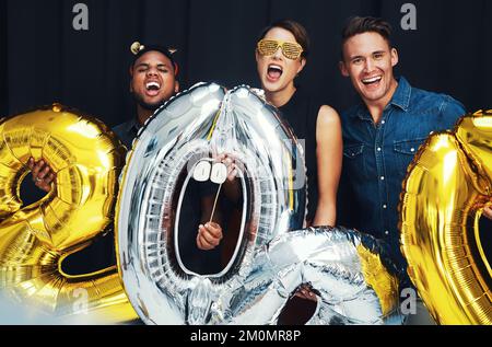 Nouvel an, heureux et amis portrait avec des ballons à une célébration sociale dans un événement photo. Heureux, sourire et bonheur de personnes prêtes Banque D'Images