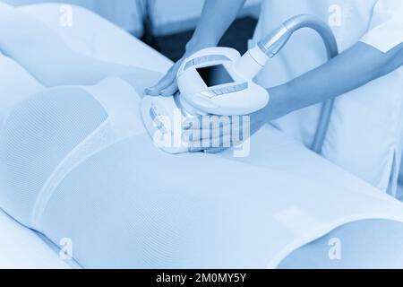 Femme en costume blanc spécial obtenir massage anti-cellulite dans un spa de beauté. Le GPL, et remodelage du corps de traitement en clinique. Banque D'Images