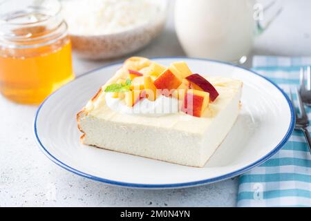 Cocotte au fromage cottage, zapekanka, gâteau à la ricotta servi avec yaourt grec, pêche et miel. Alimentation saine riche en calcium et protéines, faible Banque D'Images