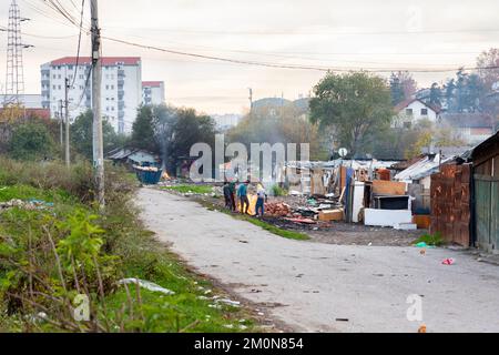 Belgrade, Serbie - 17 novembre 2022: Groupe d'enfants tziganes autour du feu dans les zones pauvres. Les Roms vivent dans la pauvreté, près de la décharge remplie de léguars Banque D'Images