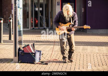 Hanley-Stoke-on-Trent, Staffordshire-Royaume-Uni 21 avril 2022 un homme adulte aux cheveux gris joue de la guitare et chante dans une rue urbaine. Musicien de rue Banque D'Images