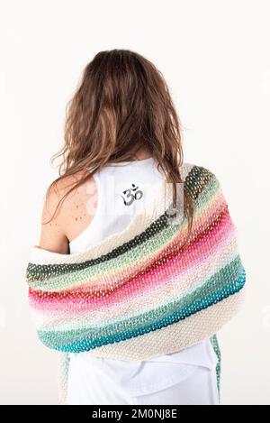 Dos d'une femme portant un t-shirt avec un signe Om. Prise de vue en studio. Femme de yoga. arrière-plan blanc Banque D'Images
