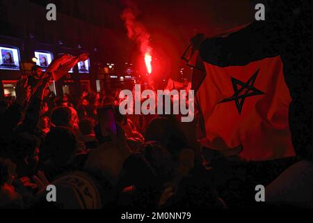 Les supporters de l'équipe de football marocaine célèbrent leur victoire sur l'Espagne lors de la coupe du monde Qatar 2022 avec des fusées rouges allumées à Madrid. Des centaines de personnes se rassemblent dans les rues du centre de Madrid pour célébrer la victoire du Maroc sur l'Espagne. Banque D'Images