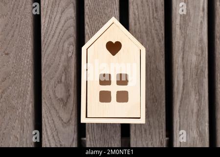 Une petite maison en bois se dresse sur un fond en bois rayé, une maison de rêve Banque D'Images