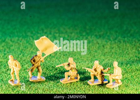 Figures de modèle en plastique Airfix HO/00. Cinq infanterie japonaise de la deuxième guerre mondiale, diverses figures en poses sur fond vert de texture d'herbe Banque D'Images