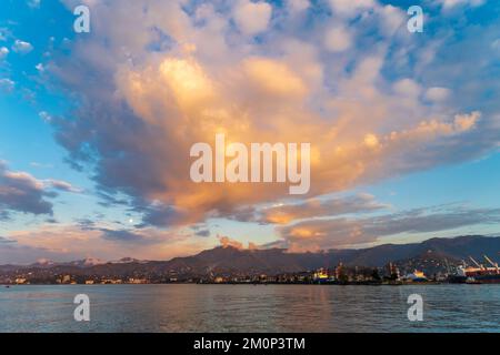 Magnifique paysage marin naturel au coucher du soleil avec des nuages lumineux et colorés au-dessus des montagnes et de la mer. Banque D'Images