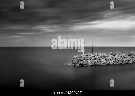 Paysage marin infrarouge noir et blanc à exposition longue du port d'Agiokampos , Grèce Banque D'Images