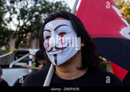 Chiang Mai, Thaïlande. 6th décembre 2022. Un manifestant portant un masque anonyme Guy Fawkes tenant un drapeau lors d'une protestation contre la peine de mort prononcée par la junte birmane à l'encontre de 7 étudiants universitaires birmans. Les étudiants de l'Université de Dagon ont été arrêtés en avril pour leur implication présumée dans la fusillade d'un ancien officier militaire. (Image de crédit : © Thuya Zaw/ZUMA Press Wire) Banque D'Images