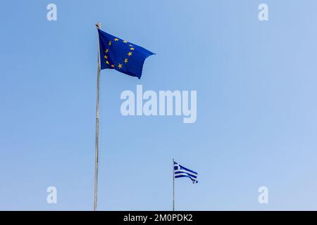 Union européenne les drapeaux de l'UE et de la Grèce flottent dans l'air sur fond bleu ciel. Bannière, place pour le texte. Photo de haute qualité Banque D'Images