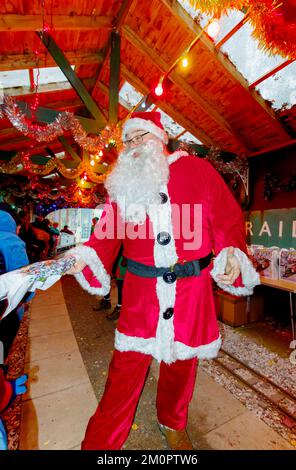 Le Père Noël donne des cadeaux à l'événement spécial annuel du Père Noël au Mizens Railway à Woking, Surrey, un événement avec des promenades en train miniature pour les enfants Banque D'Images