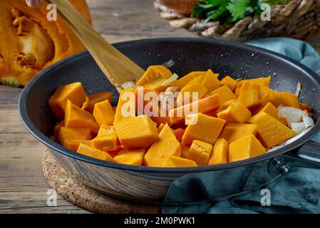 morceaux de potiron tranchés sur un plat de cuisson pour préparer des aliments végétariens sains, soupe à la crème de potiron Banque D'Images
