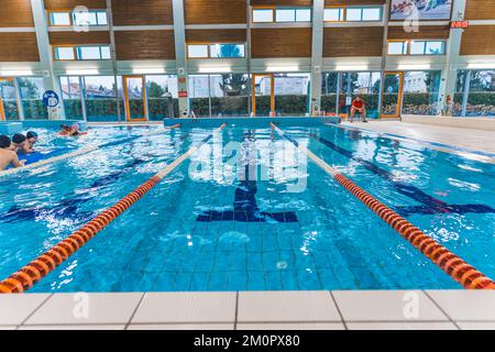 Prise de vue en intérieur avec mise au point centrale sur la piste de natation. Piscine intérieure. Activités et concept sportif. Séparateurs de pistes en plastique orange, blanc et bleu. . Photo de haute qualité Banque D'Images