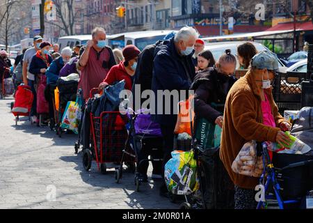 Les gens dans un garde-manger dans le quartier East Village de Manhattan, 19 mars 2022. Le garde-manger est géré par Hope for the future Ministries. Banque D'Images