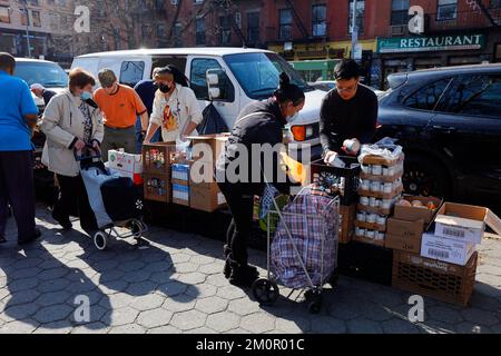 Les gens dans un garde-manger dans le quartier East Village de Manhattan, 19 mars 2022. Le garde-manger est géré par Hope for the future Ministries. Banque D'Images