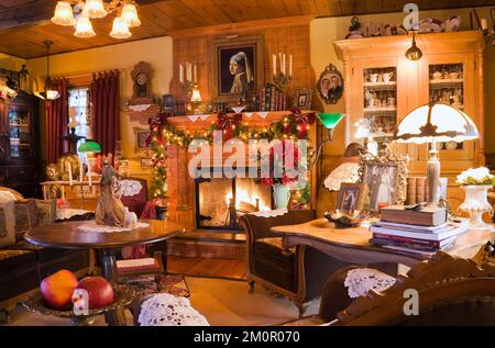 Salon somptueusement décoré à l'heure de Noël à l'intérieur de 1977 réplique construite de l'ancienne cabane en rondins de style cottage Canadiana de 1800s. Banque D'Images