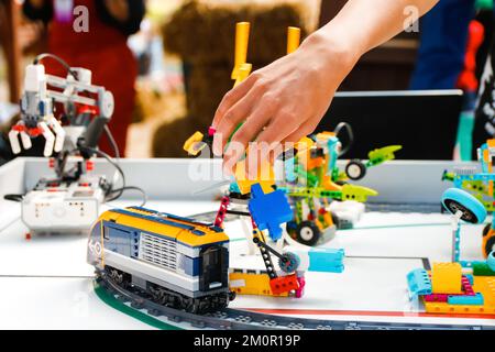 Permet de déconcentrer les mains des enfants en tenant des robots prêts à l'emploi sur la table. Former un chemin de fer. Joyeuse et intelligente, Whizzkid expérimente avec une main robotique humanoïde pendant que deve Banque D'Images