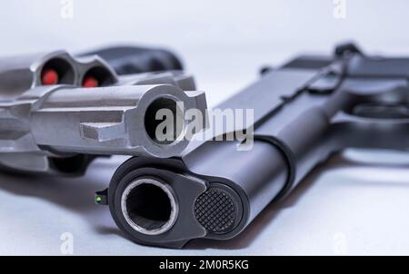 Deux pistolets, un pistolet de calibre 45 et un revolver spécial 44 empilés ensemble sur un fond blanc Banque D'Images
