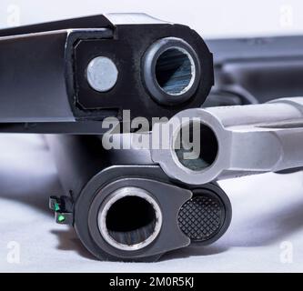 Les muzzles de trois armes de poing empilées ensemble. Un revolver spécial de calibre 45, de calibre 40 et de calibre 44 sur fond blanc Banque D'Images