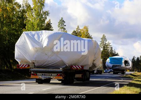 Un convoi de deux camions lourds transportant des bâches couvrait de larges charges sur la voie publique. Vue arrière. Raasepori, Finlande. 23 septembre 2022 Banque D'Images