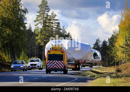 Les voitures de la direction opposée se présentent alors que deux grands véhicules de transport de charge assistés par des pilotes et des véhicules d'escorte se déroulent. Raasepori, Finlande. 23 septembre 2022 Banque D'Images