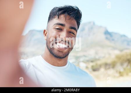 Portrait d'un homme de course mixte prenant un selfie et souriant pendant un entraînement à l'extérieur dans la nature. Un homme de bonne forme indien qui prend une photo de lui-même semble heureux Banque D'Images