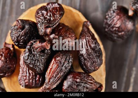 Figues de mission séchées sur scène en bois et fond en bois. Mise au point sélective. Gros plan Banque D'Images