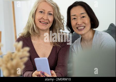 Portrait de deux amies âgées regardant la caméra tout en ayant un bon tme ensemble à la maison Banque D'Images